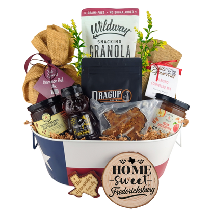 Fredericksburg Family Breakfast Basket on a white background, showcasing pecan coffee, granola, cinnamon rolls, jalapeño cornbread mix, pecan apple butter, raw honey, and praline.