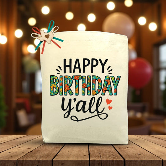 Canvas tote bag with the phrase “Happy Birthday Y’all,” styled with a festive design, perfect for filling with customizable Texas snacks and treats.