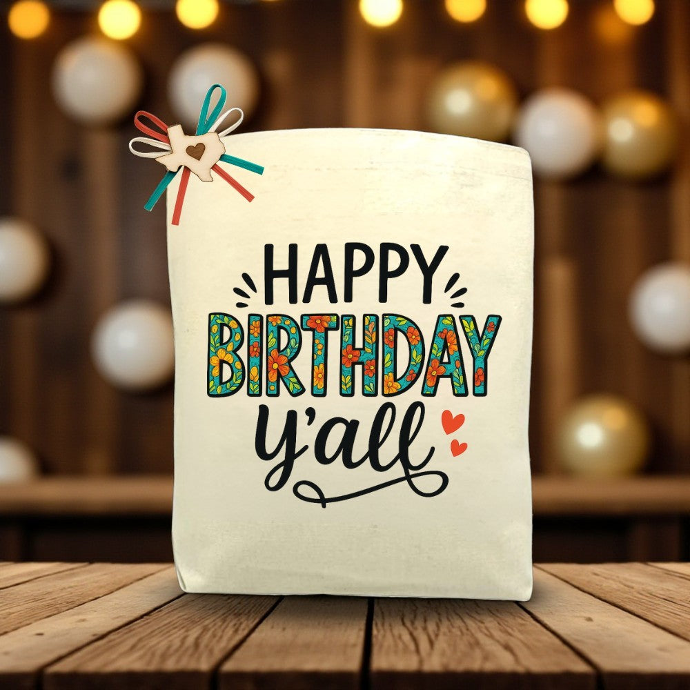 Happy Birthday Y’all canvas tote bag with festive Southern-inspired birthday design, displayed on a wooden table.