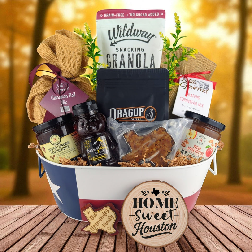 Houston Home Breakfast Basket with rustic background, Texas-themed tin filled with pecan coffee, cinnamon roll mix, jalapeño cornbread mix, granola, honey, praline, and preserves.