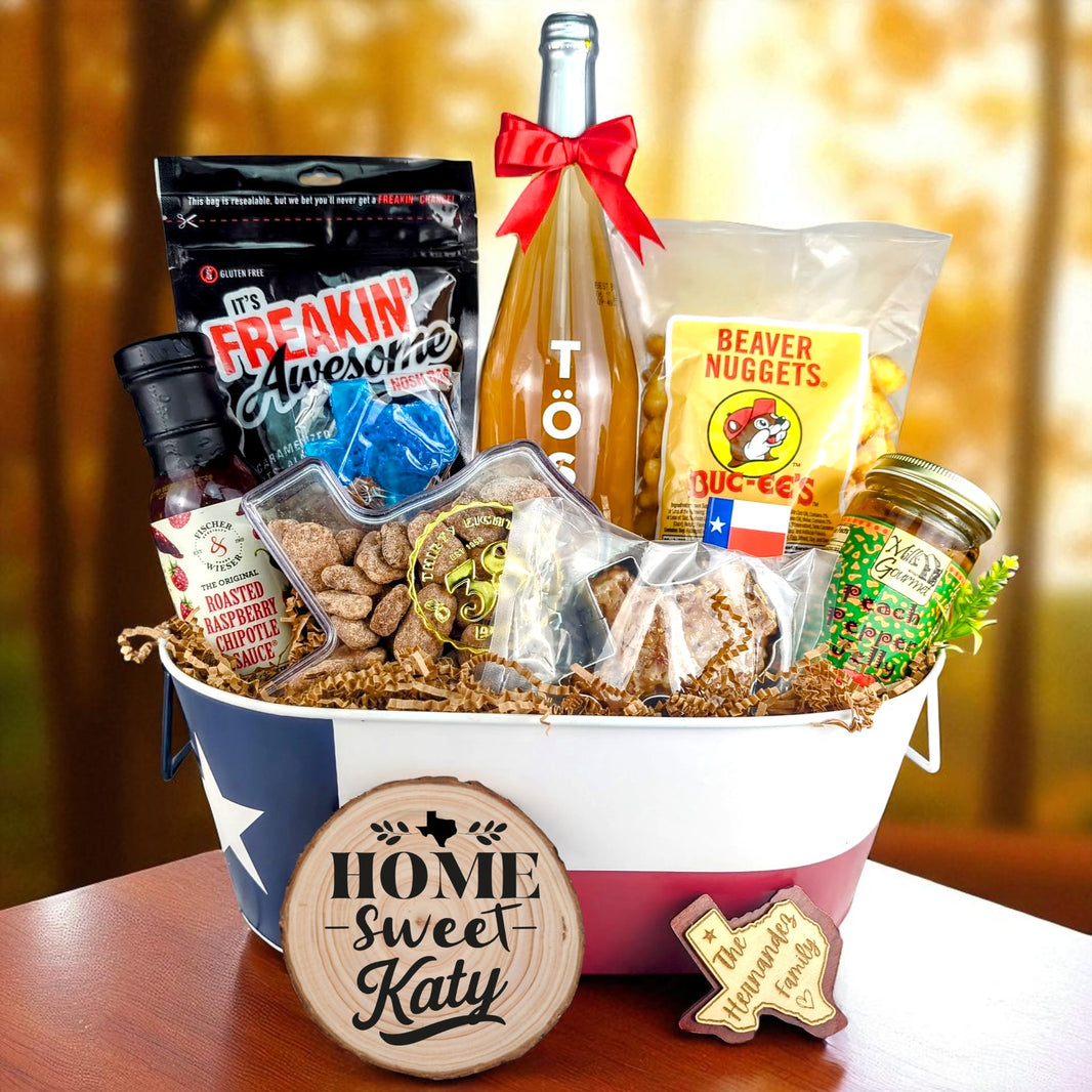 Katy Texas Family Home Toast & Treats basket with TÖST ROSÉ, Peach Pepper Jelly, Buc-ee’s Beaver Nuggets, Texas pecans, praline, chipotle sauce, and Texas flag tin