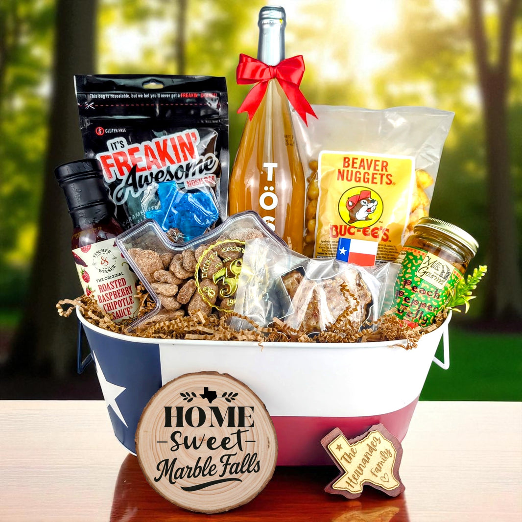 Marble Falls Texas Family Home Toast & Treats basket with TÖST ROSÉ, Peach Pepper Jelly, Buc-ee’s Beaver Nuggets, Texas pecans, praline, chipotle sauce, and Texas flag tin