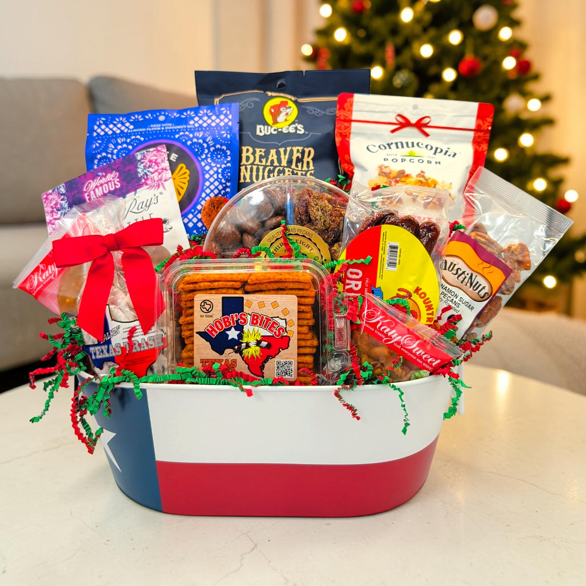 Merry & Bright Texas Bites holiday gift in a Texas flag tin by a Christmas tree