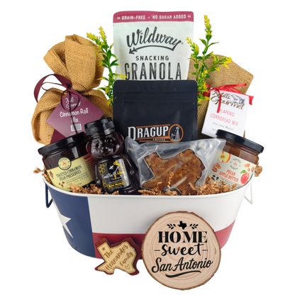 San Antonio Family Breakfast Basket on a white background, showcasing pecan coffee, granola, cinnamon rolls, jalapeño cornbread mix, pecan apple butter, raw honey, and praline.