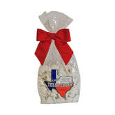 Clear gift bag of Talkin’ Texas Trash white chocolate–coated snack mix tied with a red ribbon