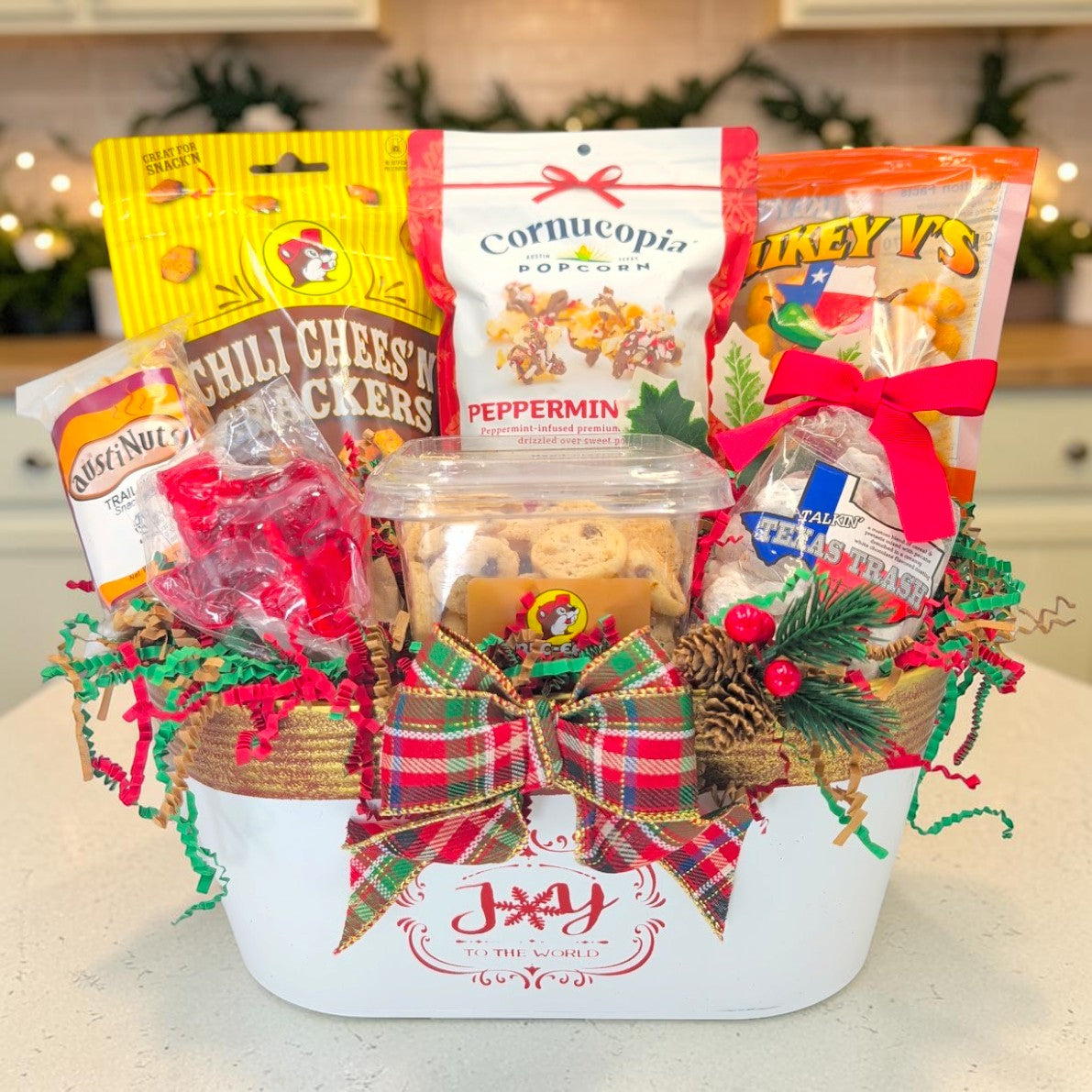 Texas Christmas Joy gift with seven snacks in a Joy to the World metal container with plaid bow and Christmas greenery
