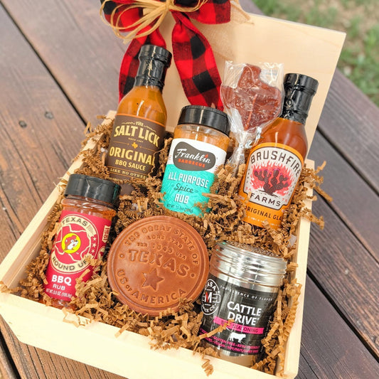 Angled view of Texas Pitmaster Pantry showing seven barbecue favorites and keepsakes arranged in a wooden gift box.