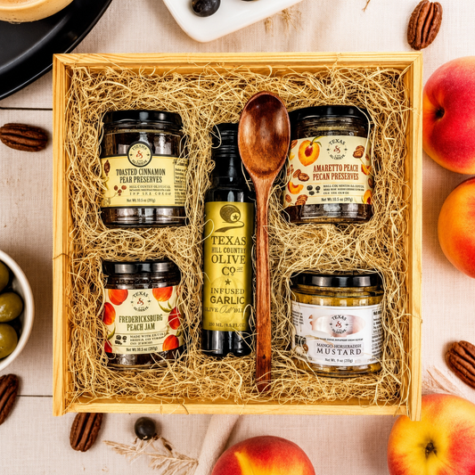 a texas hill country themed gift box with preserves, mustard, olive oil, and jam in excelsior in a wooden box
