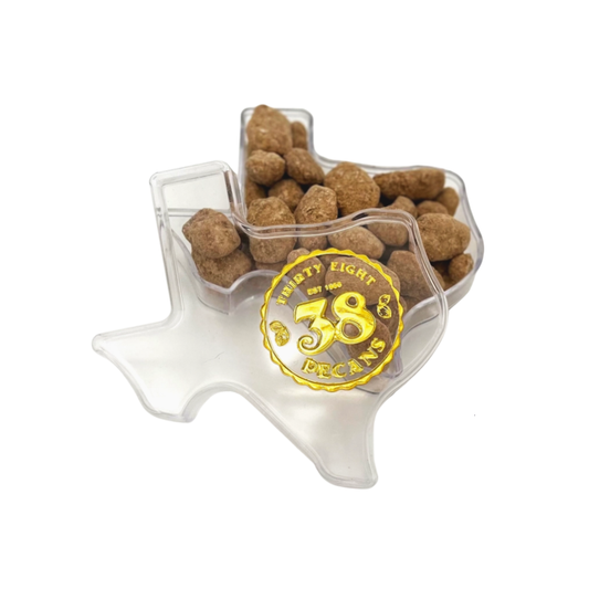 a texas shaped acrylic gift container filled with cinnamon spiced pecans 