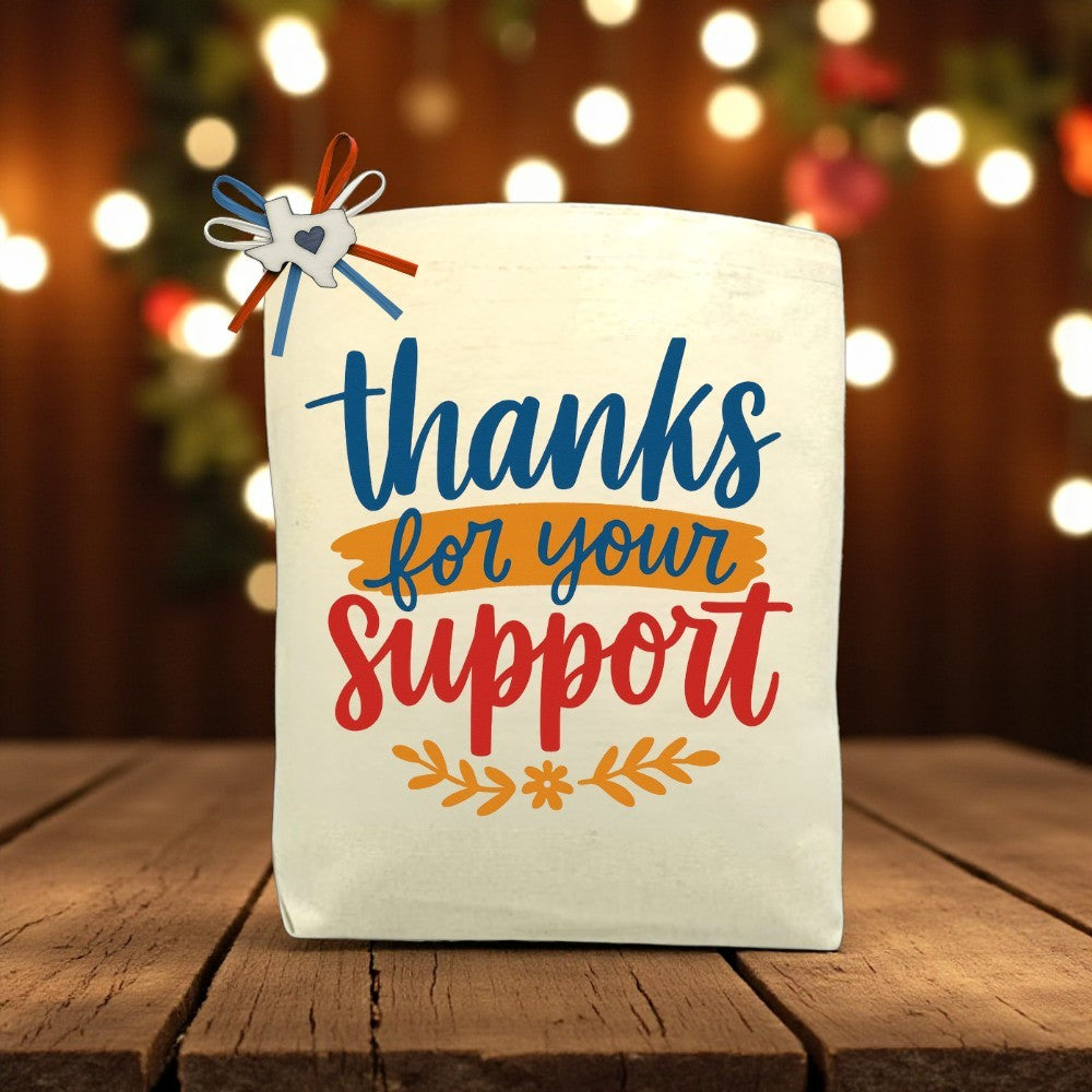 Thanks For Your Support canvas tote bag with gratitude-inspired design, displayed on a wooden table.